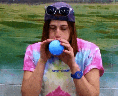woman blowing up balloon gif