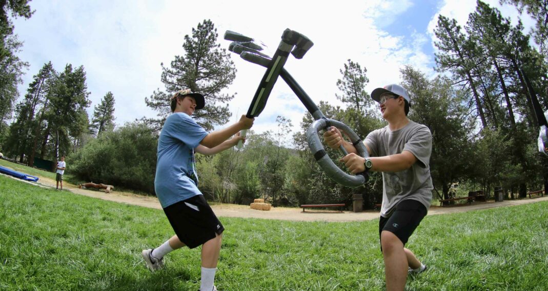 Boys fighting with swords.