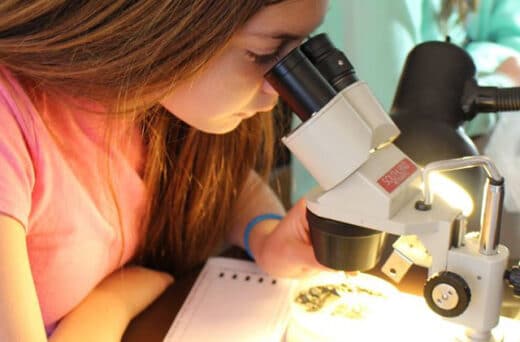 Girl looking into microscope.
