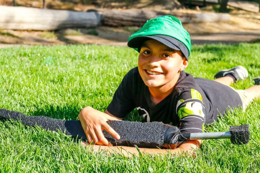 Boy lying in grass smiling.
