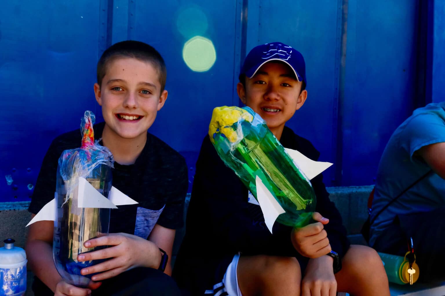 Boys smiling holding rockets.