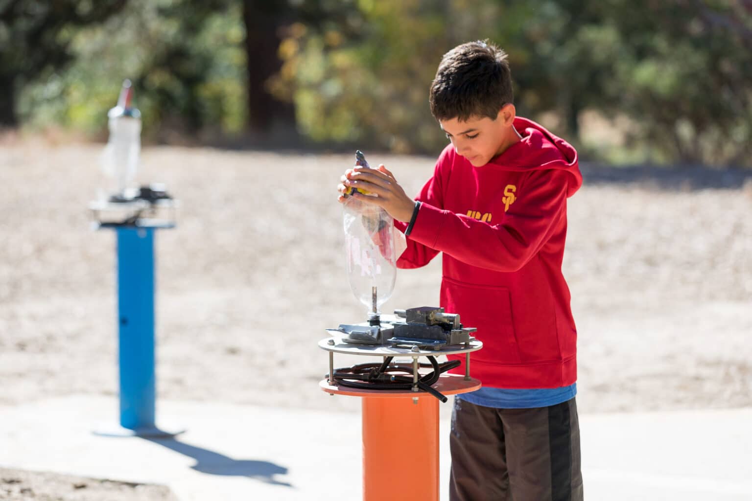 Boy building bottle rocket.