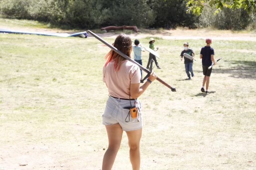 Girl walking holding a pole.