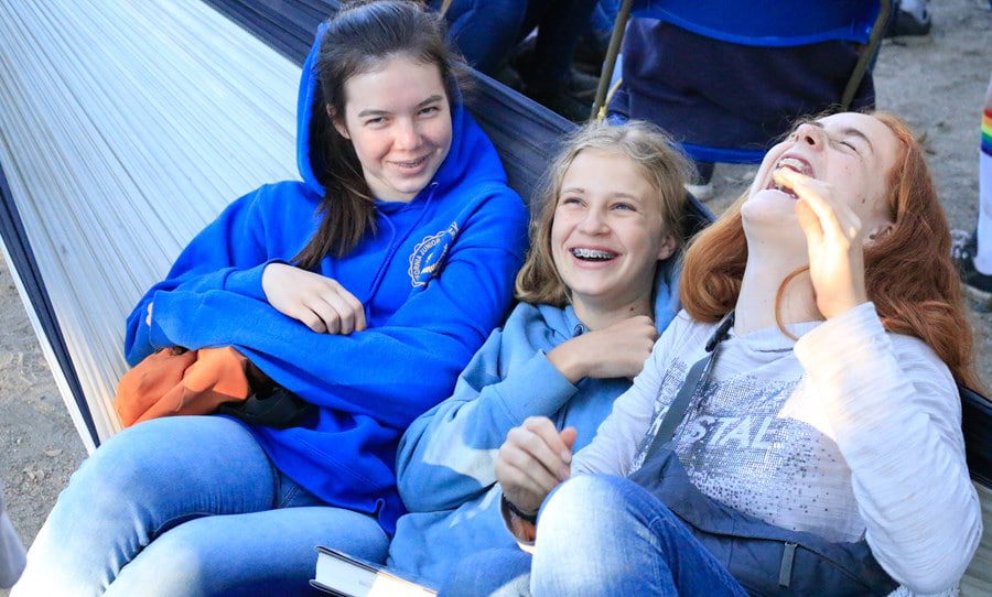 Girls laughing on hammock.