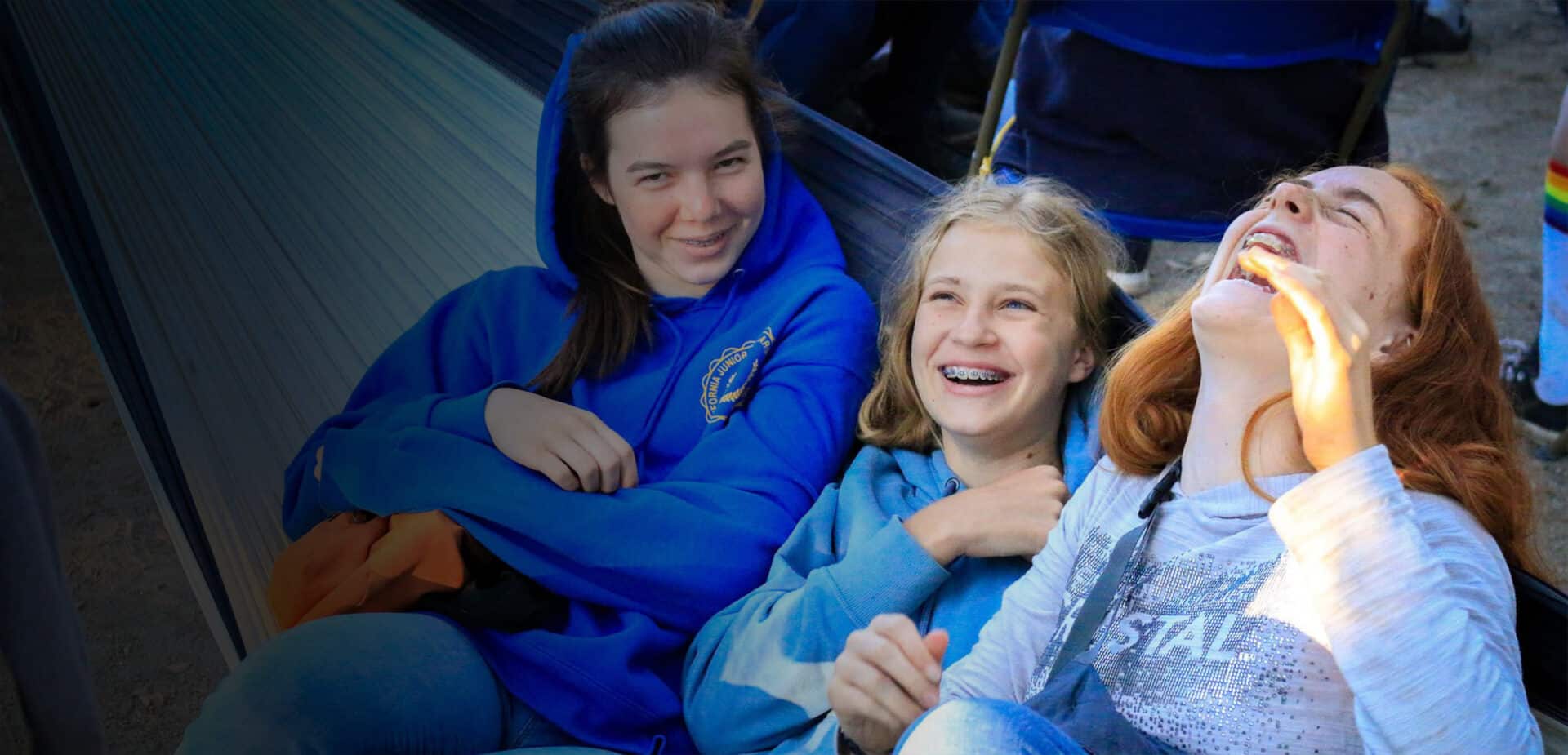 Girls laughing on hammock.