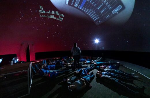 Kids laying under virtual stars.