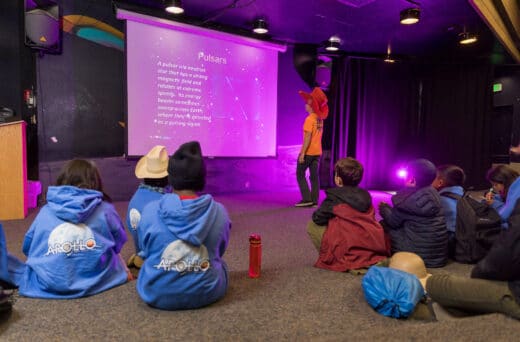 Kids sitting in front of projector.