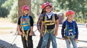 Kids smiling in zipline gear.