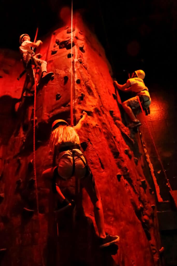 Three kids rock-climbing.