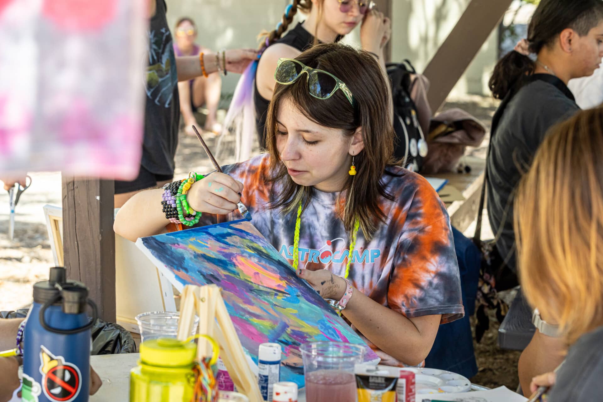 Camper focused on painting activity, exploring creativity at camp.