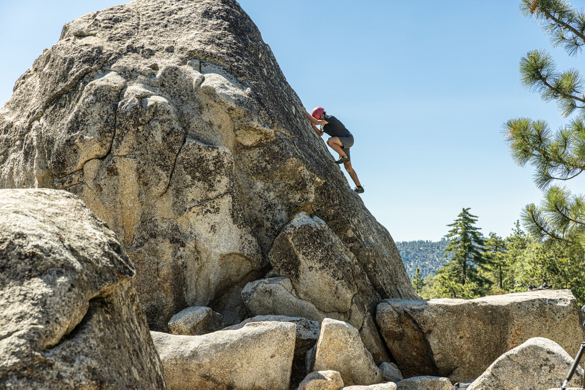Camper exploring bouldering challenge, building strength and confidence.