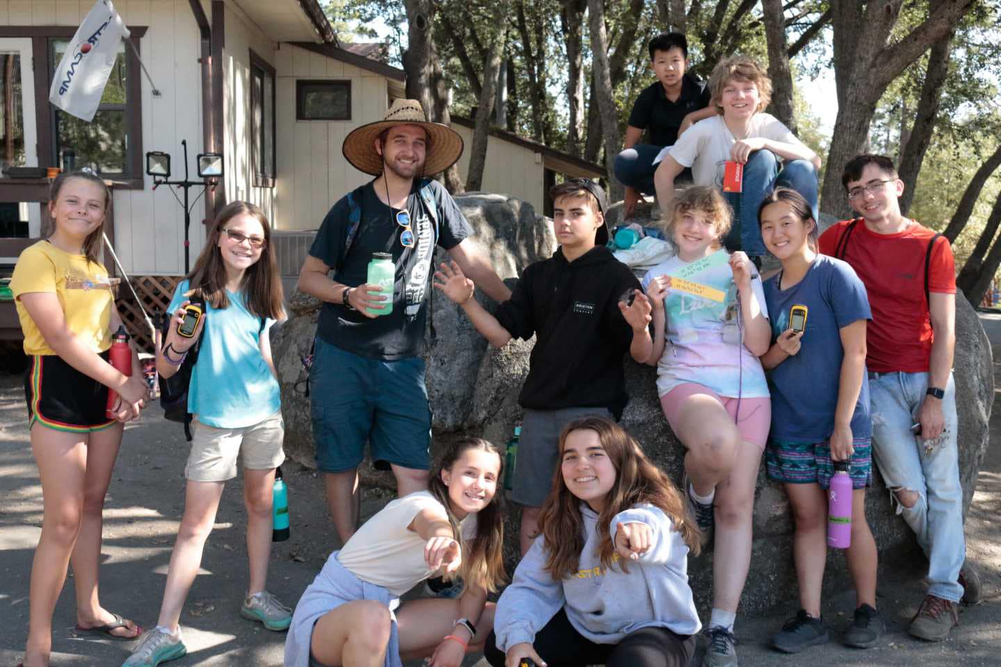 Staff and kids posing on rock.
